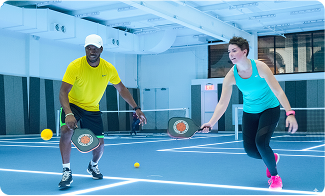 Players competing in an indoor Texas Pickleball doubles match