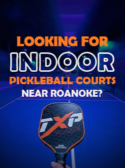 Promotional graphic showing an indoor pickleball court with blue lighting and a hand holding a pickleball paddle in the foreground. Bold text reads, “Looking for Indoor Pickleball Courts Near Roanoke?” highlighting an indoor pickleball facility search.